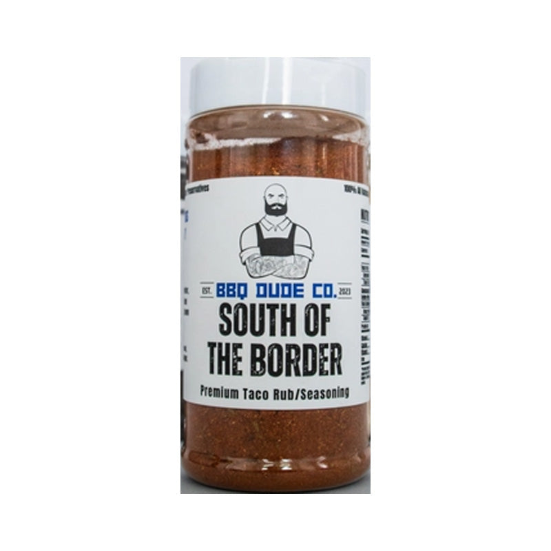 BBQ Dude South of the Border Taco Seasoning bottle beside tacos and fresh lime wedges.