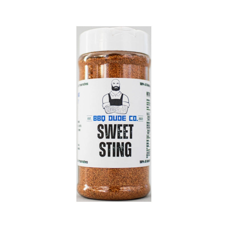 BBQ Dude Sweet Sting Honey Chipotle Seasoning bottle beside glazed ribs on grill.