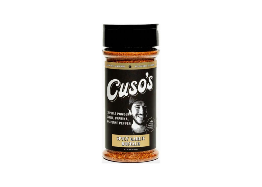 Bottle of Cuso’s Spicy Garlic Buffalo Seasoning next to a plate of buffalo wings with celery and blue cheese dip