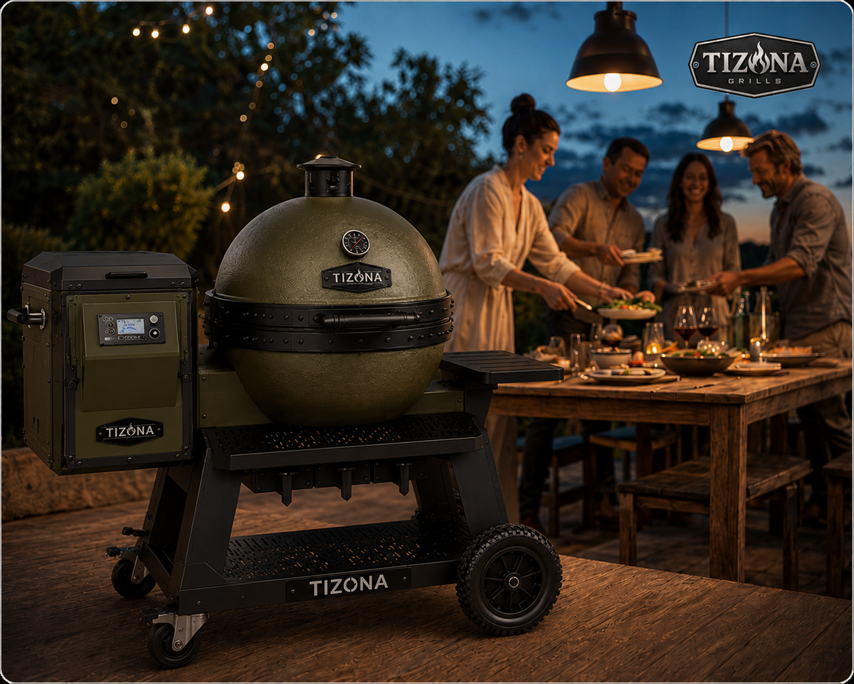 A Tizona kamado grill glowing at dusk on a wooden patio while friends gather around a table strung with lights